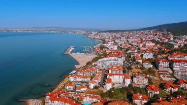 Canlı bir sahil kasabasının kıyı manzarası. Renkli bir sahil kasabasına bakan kayıklar demirli Güneş berrak mavi gökyüzünde parlarken.