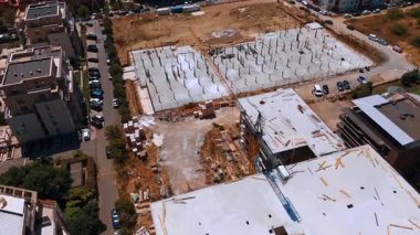 Şehir şantiyesi. İşçiler, gündüz saatlerinde kentsel bir alanda temel oluşturan büyük bir inşaat sahası inşa ediyorlar..