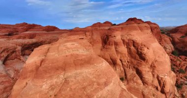 Kırmızı kanyonlar rüzgar gücüyle oluşturuldu. Nadir çalılarla kaplı ıssız arazinin üzerinden uçmak. Arches Ulusal Parkı, Utah, ABD.