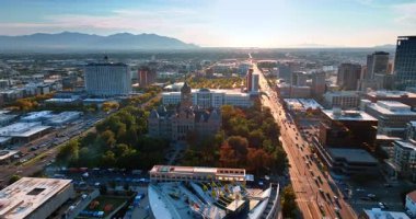 Salt Lake City, Utah, ABD 'deki güzel Salt Lake City ve County binasına uçuyoruz. Gün batımında birden fazla hareket eden arabanın olduğu güneş ışığında manzaraya bak..