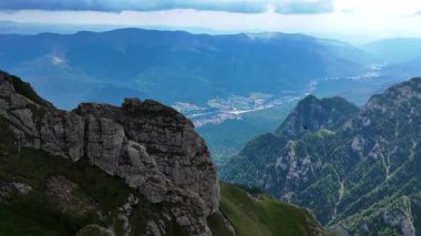 Busteni Romanya 'nın dağlarını ve vadilerini keşfedin. Romanya 'nın Busteni kentinin muhteşem manzaraları ve bulutlu gökyüzünün altında yemyeşil bir vadi.