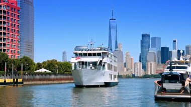 Jersey City, ABD, 16 Temmuz 2025, Manhattan yakınlarındaki feribot Jersey City 'den izlendi. Arka planda Manhattan gökdelenleri olan Hudson Nehri 'nden bir feribot kalkıyor..
