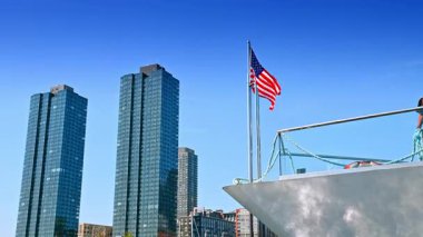 Jersey City, ABD, 16 Temmuz 2025: Jersey City 'de Amerikan bayrağı taşıyan gökdelenler. Jersey City rıhtımında yükselen modern gökdelenler ön planda Amerikan bayrağıyla.