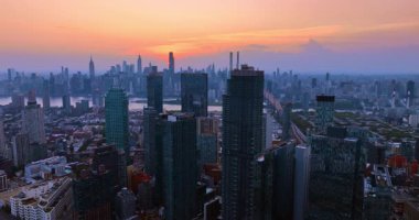 Manhattan gökdelenli gün batımında gökyüzü. Günbatımının ışığı New York 'taki yüksek gökdelenleri aydınlatan Manhattan siluetini renklendiriyor..