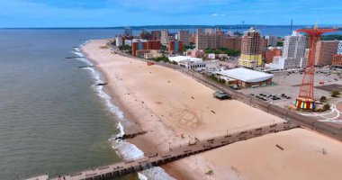 New York 'taki Coney Adası plajı. Coney Adası 'nın kumlu plajında New York' taki rıhtım boyunca sıra sıra binalar vardı..