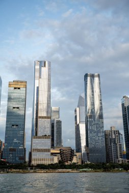 Hudson Yards gökdelenleri yansıtıcı cam cepheleriyle. Manhattan 'daki Hudson Metrelerinin uzun camlı gökdelenleri açık bir günde ışığı yansıtır.