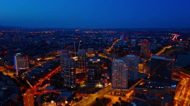 Bratislava gökdelenleri aydınlatılmış gece gökdelenleri. Bratislava 'nın modern gökdelenleri akşam gökyüzüne karşı parlak ışıklarla parıldıyor..