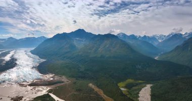 Alaska 'daki vadi ve dağları kesen nehir. Alaska 'daki yeşil vadilerden ve dağlardan akan dolambaçlı bir nehir, yukarıdan yakalanır..