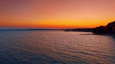 Bulgaristan 'da Karadeniz üzerinde canlı bir günbatımı. Sveti Vlas yakınlarında gün batımında turuncu ve mor renkli Karadeniz ufkunun dramatik hava manzarası.