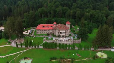 Romanya 'nın Busteni kentindeki Cantacuzino Şatosu' nun güzel topraklarına gidiyoruz. Turistler şehir simgesinde yürürler..