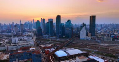 Modern Brooklyn, New York demiryolları. Tren şehir manzarasına göre hareket ediyor. Gün batımında gökyüzünden Büyük Elma.