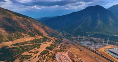 Rüzgar türbinleri, ABD 'nin Utah kentindeki İspanyol Fork şehrinde yenilenebilir enerji üretiyorlar. Dramatik bulutlar manzarayı kaplıyor..