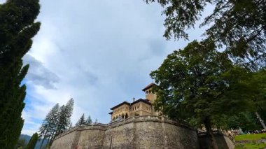 Romanya 'nın Busteni kentindeki Cantacuzino Kalesi' nin terası ve kuleleri. Düşük açı. Çevresindeki yeşil ağaçlar.