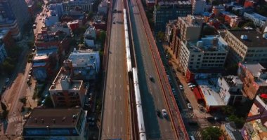 New York, ABD, 1 Ağustos 2025: Brooklyn, New York, ABD 'deki Williamsburg Köprüsü yakınlarındaki demiryollarında toplanan trenleri izlemek. Arabalar demiryolu boyunca otobanlardan geçer. Hava görünümü.