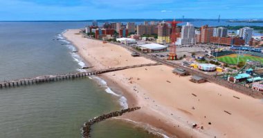 New York, ABD, 1 Ağustos 2025: Kumlu sahil boyunca uçuş. Coney Adası, New York, ABD 'deki eğlence parkına hava perspektifi.