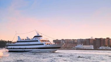 New York, ABD, 4 Ağustos 2025, New York Hudson Nehri 'nde gün batımında bir yolcu gemisi ve jet ski, gün batımında Hudson Nehri boyunca ilerler.