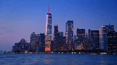 Alacakaranlıkta Dünya Ticaret Merkezi ile New York silueti. Günbatımında aydınlanan bir Dünya Ticaret Merkezi ile New York şehrinin ufuk çizgisi