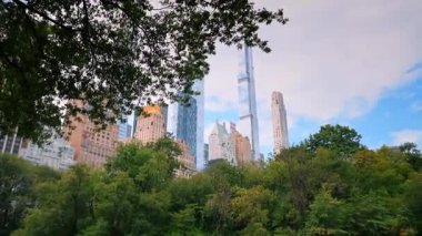 New York, ABD, 4 Ağustos 2025: Central Park ağaçları tarafından çerçevelenmiş New York silueti. Gökdelenler yapraklı Central Park tepe örtüsünün üstüne bakıyor..