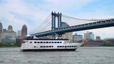 New York, ABD, 1 Ağustos 2025 Manhattan Köprüsü yakınlarındaki East River 'da yolcu gemisi. Manhattan Köprüsü 'nden New York gökdelenleriyle birlikte büyük beyaz bir yolcu gemisi geçiyor..