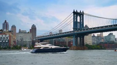 New York, ABD, 1 Ağustos 2025, Manhattan Köprüsü 'nün altında lüks bir yat. Lüks bir yat Manhattan Köprüsü 'nün arka planında yükselen Doğu Nehri' nin karşısına geçiyor..
