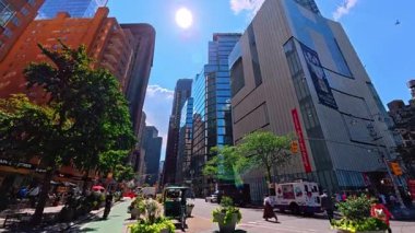 New York, ABD, 1 Ağustos 2025: New York 'ta modern gökdelenlerle sokak manzarası. Parlak güneş ışığı Manhattan 'ın cam kulelerini ve caddelerini aydınlatıyor..