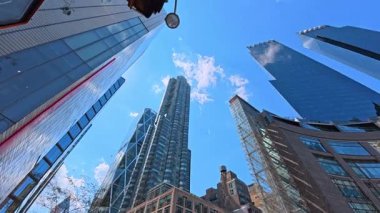 New York, ABD, 1 Ağustos 2025: Columbus Circle yakınlarındaki gökdelenlere bakıyorum. Modern cam cepheli ve berrak mavi gökyüzü olan Manhattan gökdelenlerinin dramatik yükselişi.