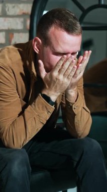 Kafkasyalı bir adam bazı sorunlarla uğraşıyor. Adam koltukta oturur, kafasından tutar ve geriye yaslanır. Dikey video