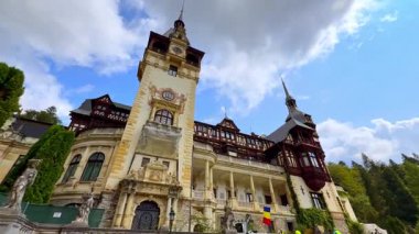 Romanya 'nın ünlü Peles Şatosu' nun güzel perişanlığı. Düşük açı. Arka planda mavi gökyüzünde bulutlar.