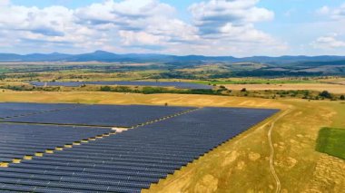 Güneş panelleri alanda yenilenebilir enerji biriktirir. Fotovoltaik paneller ile kırsal alanda drone görüntüleri.