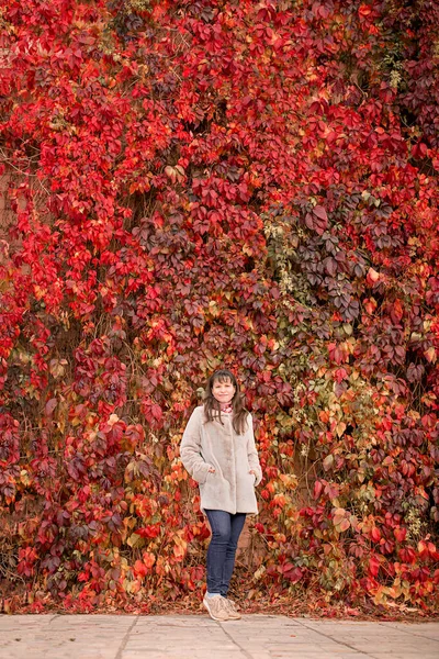Girl Beige Coat Stands Next Red Wall Grapes Autumn — Stock Photo, Image