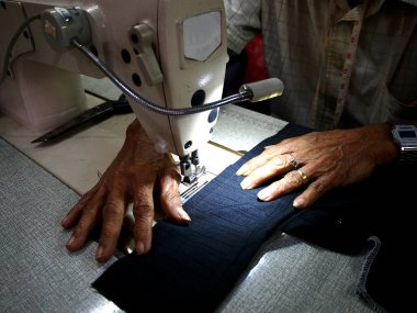 Fotoğraf bir dikiş makinesi üzerinde çalışan bir terzi eller yukarı kapatın