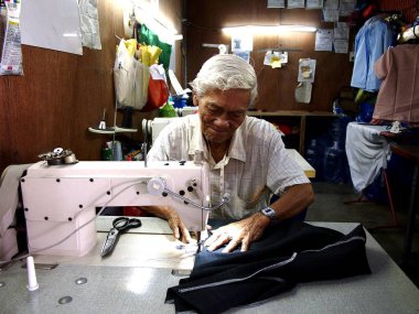 Antipolo City, Filipinler - 28 Haziran 2018: Bir elbise dükkanı eserleri bir müşteri için bir terzi.