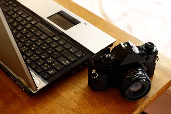 Портативный компьютер и ручная камера 35 мм — стоковое фото