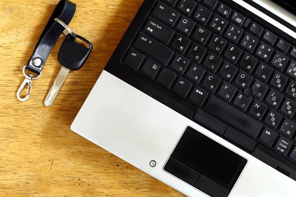 Laptop computer and car key — Stock Photo, Image