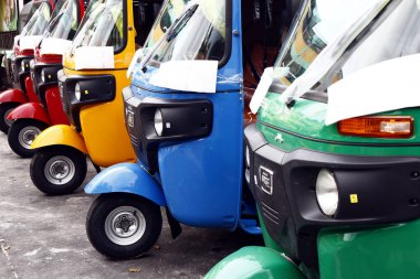 Toplu taşıma olarak kullanılan renkli üç tekerlekli otopark, halka açık bir park alanına Park edilmiştir.