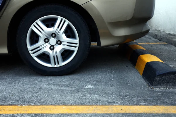 Rueda trasera de un coche y un tapón de ranura de estacionamiento —  Fotos de Stock