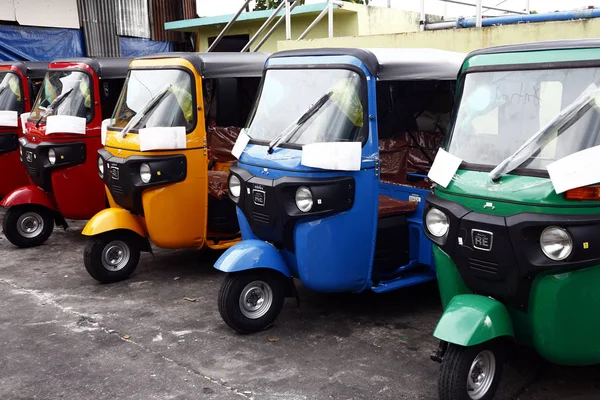 Triciclos coloridos usados como transporte público estão estacionados em uma área de estacionamento público . — Fotografia de Stock