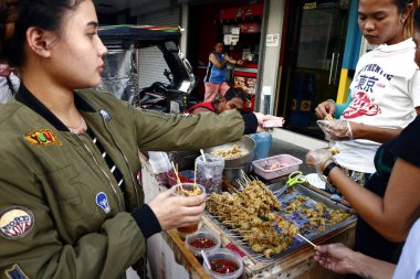 Müşteriler tavuk bağırsağı ve diğer iç organlar gibi çeşitli sokak gıda satın