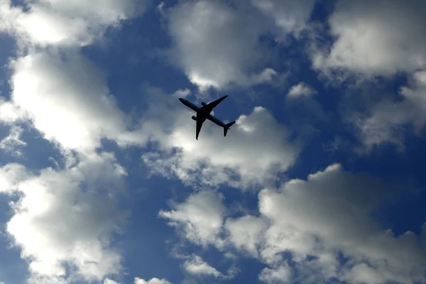 Airplane flying and clear blue sky with white clouds