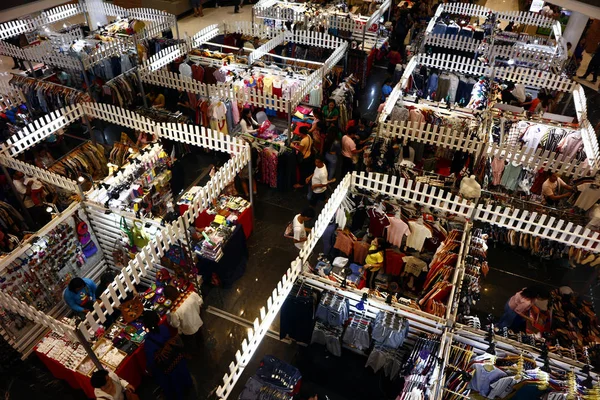 I clienti visitano e fanno acquisti presso bancarelle di bazar che vendono vestiti e altri accessori di moda — Foto Stock