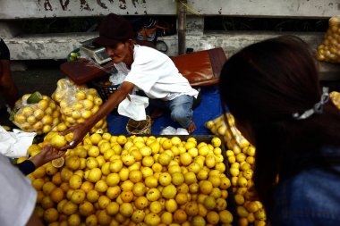 Bir sokak satıcısı bir otoyol boyunca bir kaldırımda taze ve olgun limon satıyor.