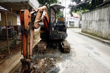 Bir ekskavatör bir yol inşaat sitesinde bir gün iş sonra yolun tarafında Park edilmiştir.