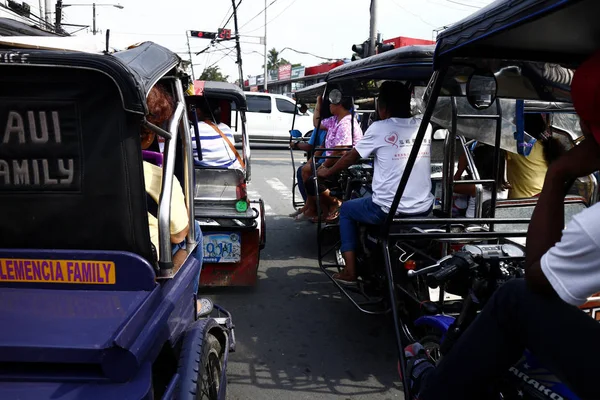 Triciclos com passageiros esperam por sua vez para se mover em um cruzamento ao longo de uma estrada movimentada . — Fotografia de Stock
