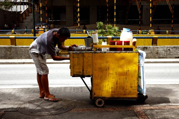Un vendedor ambulante de comida se prepara para cocinar bolas de pescado y otros artículos de merienda en su carrito de comida. . — Foto de Stock