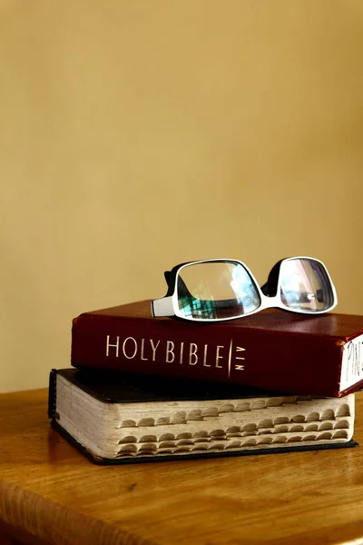 Holy Bibles on a table and eyeglasses