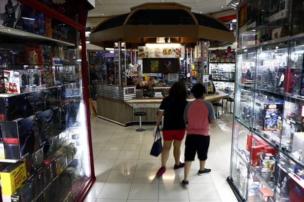 Müşteriler, ticari bir alışveriş merkezi içinde sıra sıraoyuncak mağazalar ve snack bar tarafından geçmek. — Stok fotoğraf