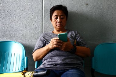 Yetişkin Filipinli adam büyük kaya oturur ve kamera için poz