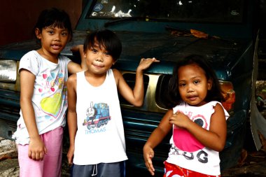 Genç Filipinli çocuklar park halindeki bir araçta oynayıp kameraya gülümse.