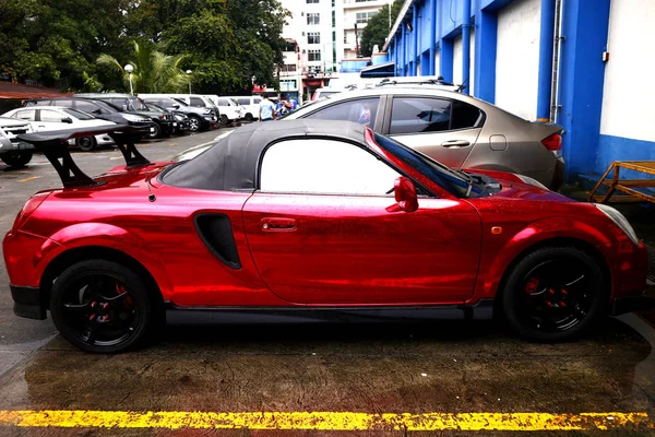 Carro esportivo vermelho estacionado em um estacionamento de um centro comercial . — Fotografia de Stock