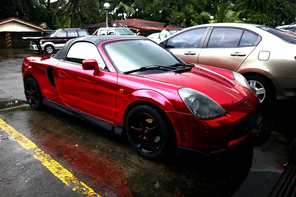 Red sports car parked at a parking lot of a commercial center. — Stock Photo, Image